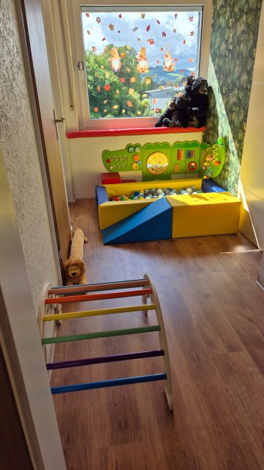 Bunte Spielzeugelemente in einem hellen Raum mit einem Fenster und dekorativen Lichtern.